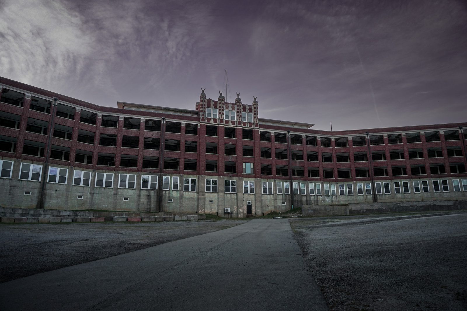 The long brick facade of Waverly Hills Sanatorium beneath a gray sky